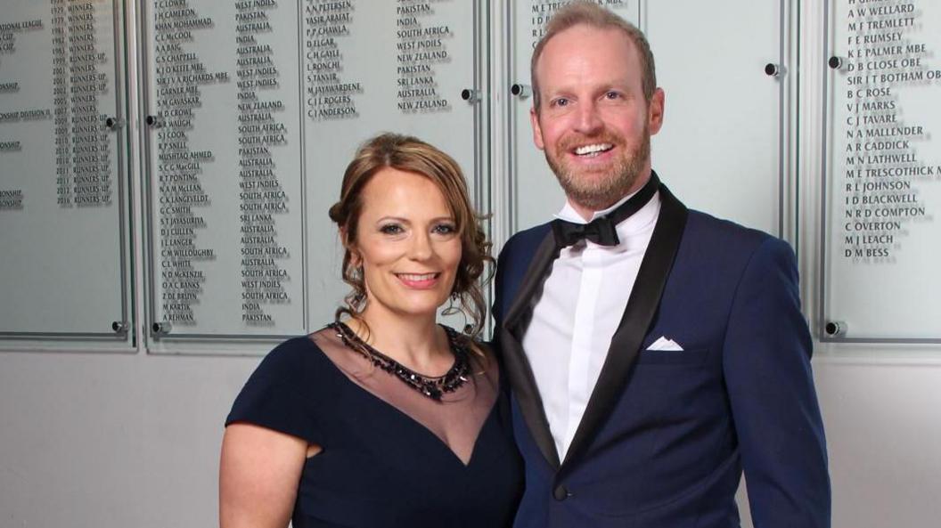 Mr and Mrs Stevens wearing smart evening wear at an event smiling at the camera