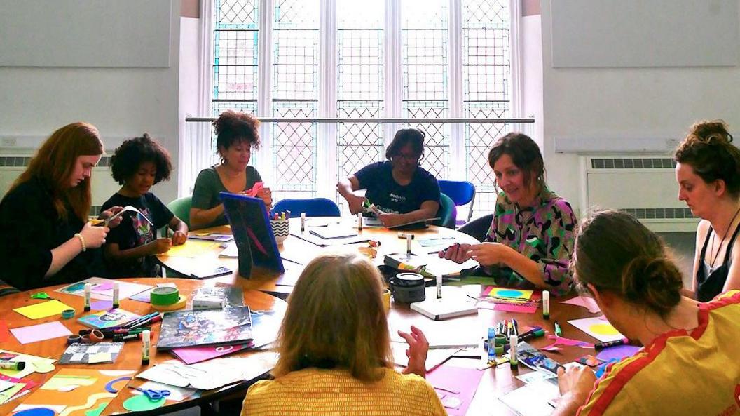 People sitting around a large table with arts and crafts