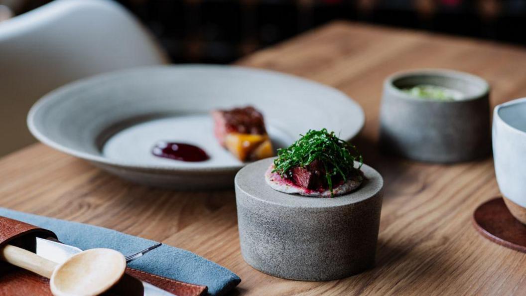 A close-up of some small dishes of food served at a table in a restaurant.