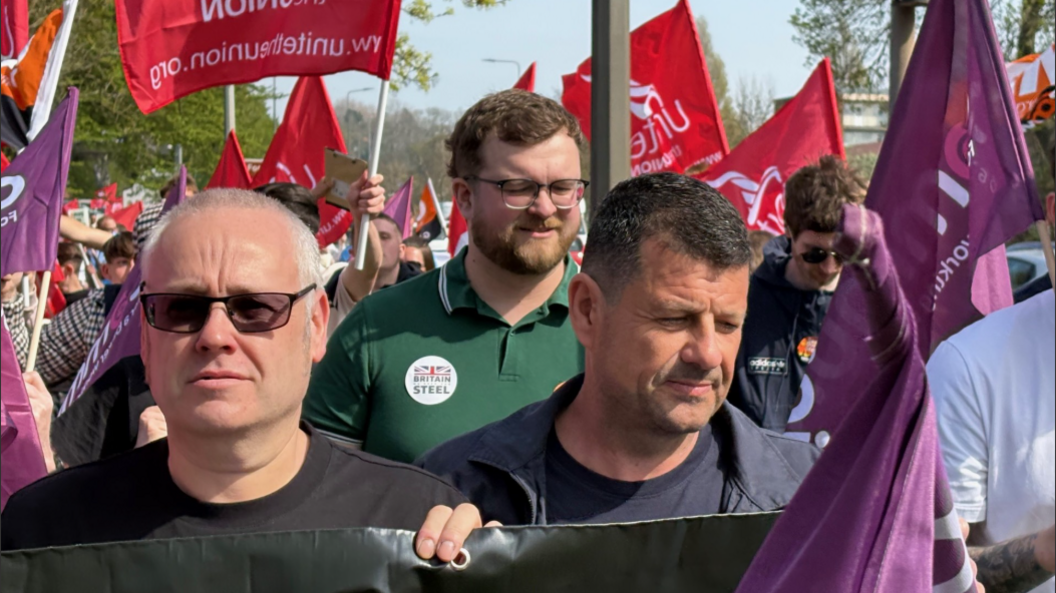 Steelworkers marching with banners.