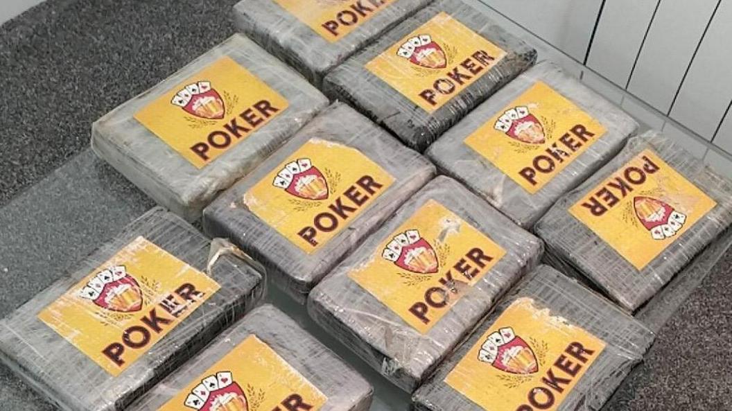 A batch of 10 blocks of cocaine, wrapped in clingfilm and accompanied by individual labels reading 'Poker'