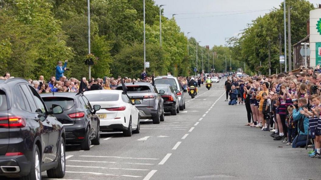 People line the route outside Featherstone Lions as the funeral procession goes past