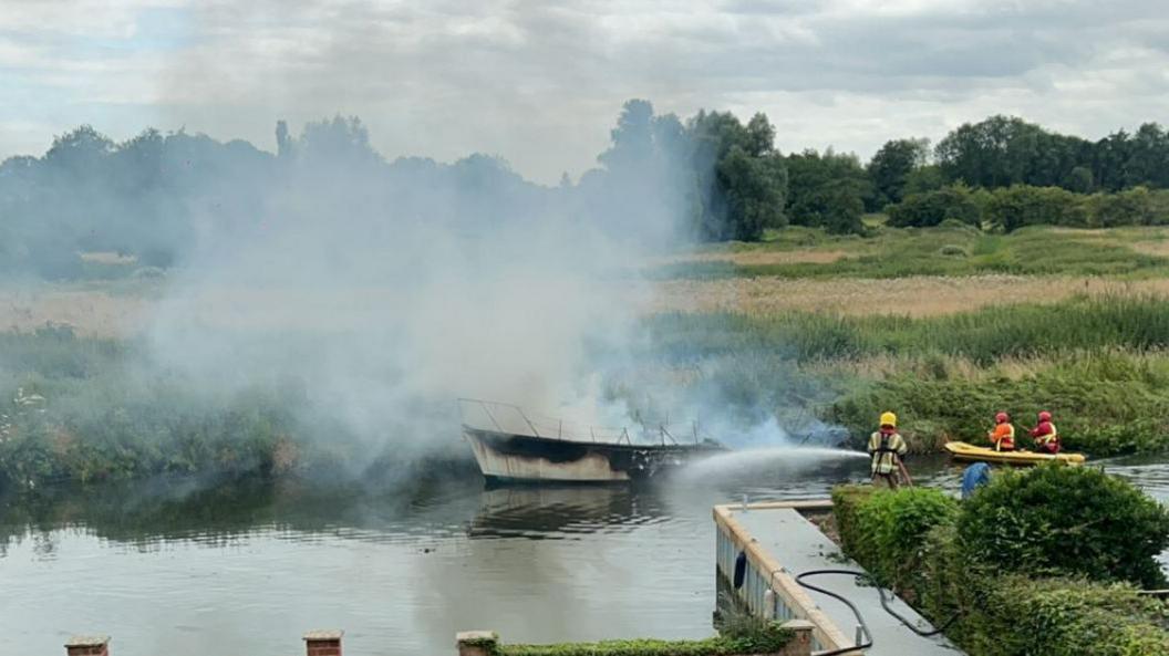 Firefighters putting out a boat fire