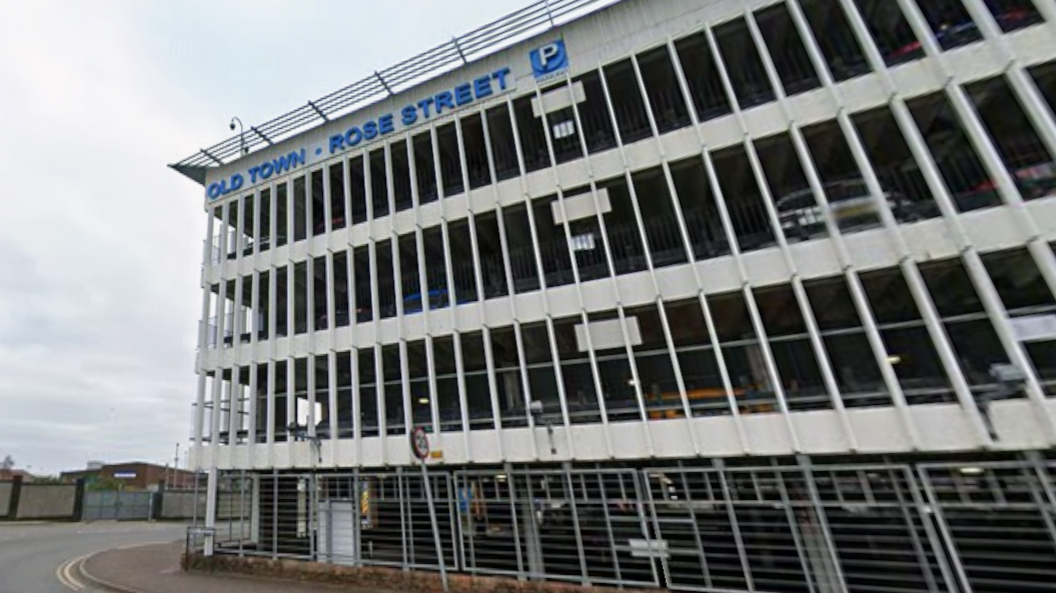 The car park has multiple storeys and is a white building with the words "Old Town" and "Rose Street" in blue lettering on the wall next to the top floor.
