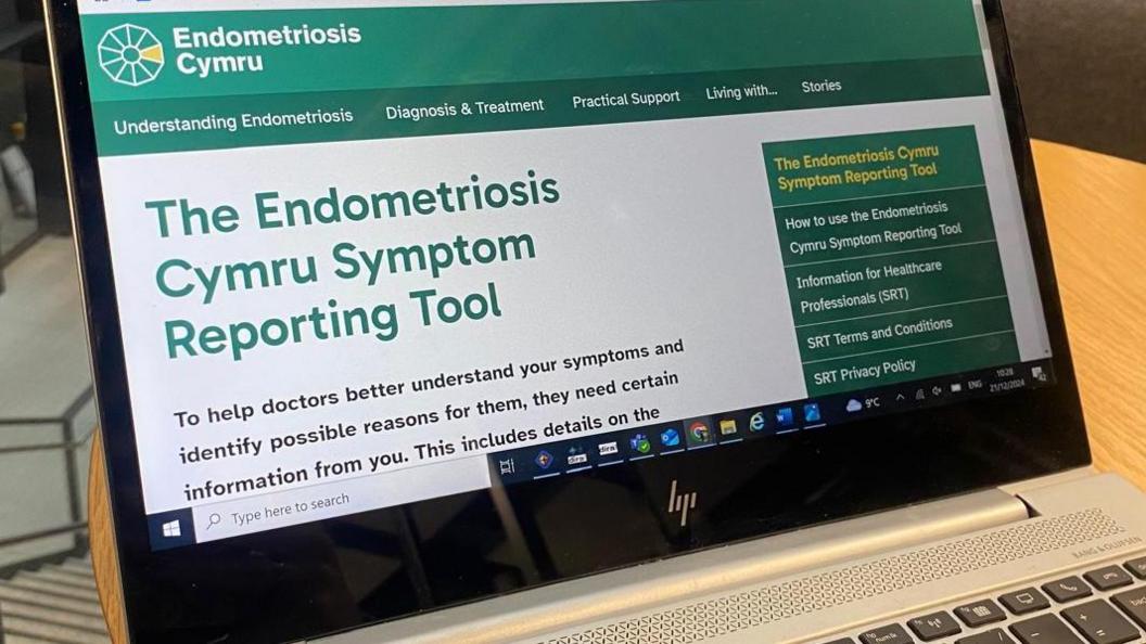 The Endometriosis Cymru Symptom Reporting Tool website homepage is shown on a HP laptop.