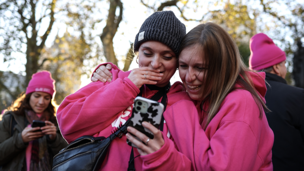 Two pro-assisted dying campaigners looking at a phone and smiling