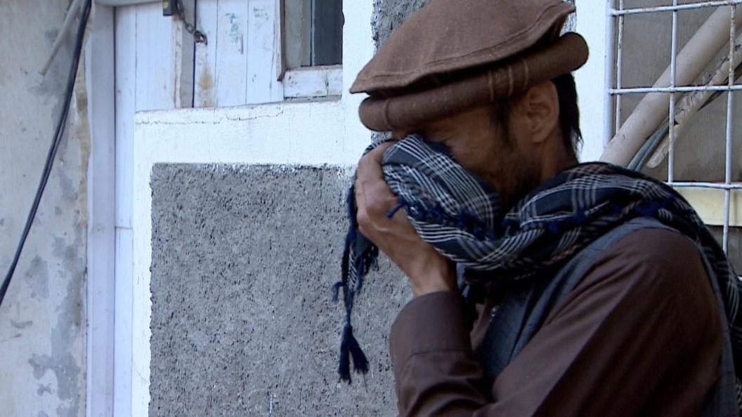 A man whose brother died in the attack cries as he informs relatives by phone from a Kabul hospital