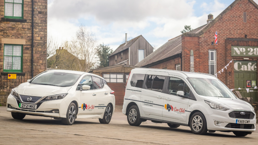 One family sized car and one wheelchair friendly van with Derbyshire Community Transport logos on the side of the vehicles. 