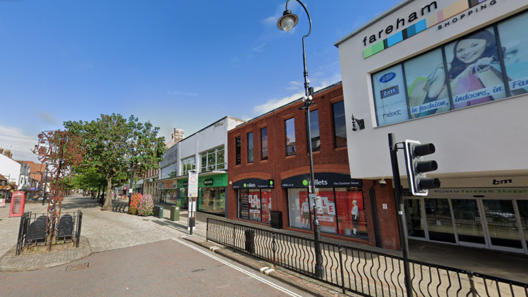 Fareham high street, a pedestrianised road with shops, plants and a red phone box.