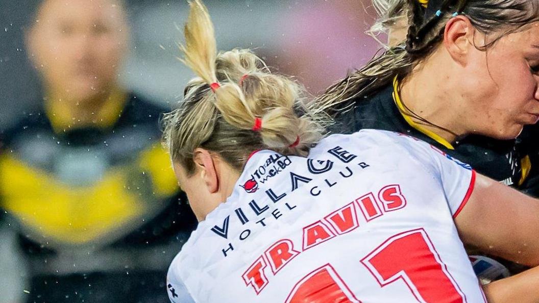 Paige Travis' distinctive hairstyle of plaits tied with hair bobbles in close up.