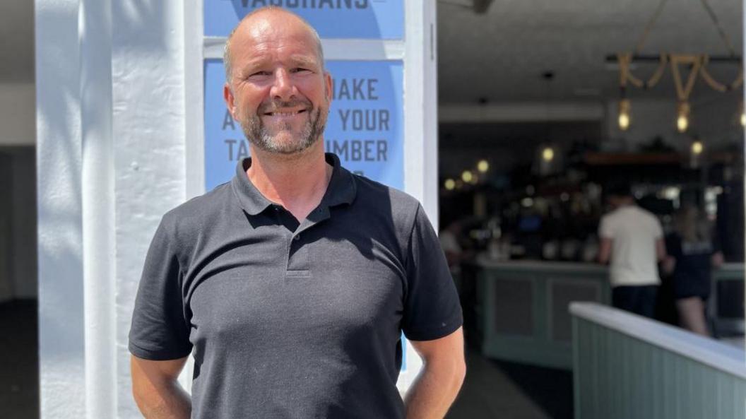 John Coote standing in front of  Vaughans Bar