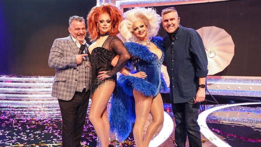 Andy is on stage with Ant & Dec who are dressed in drag and floor manager Alan Conley