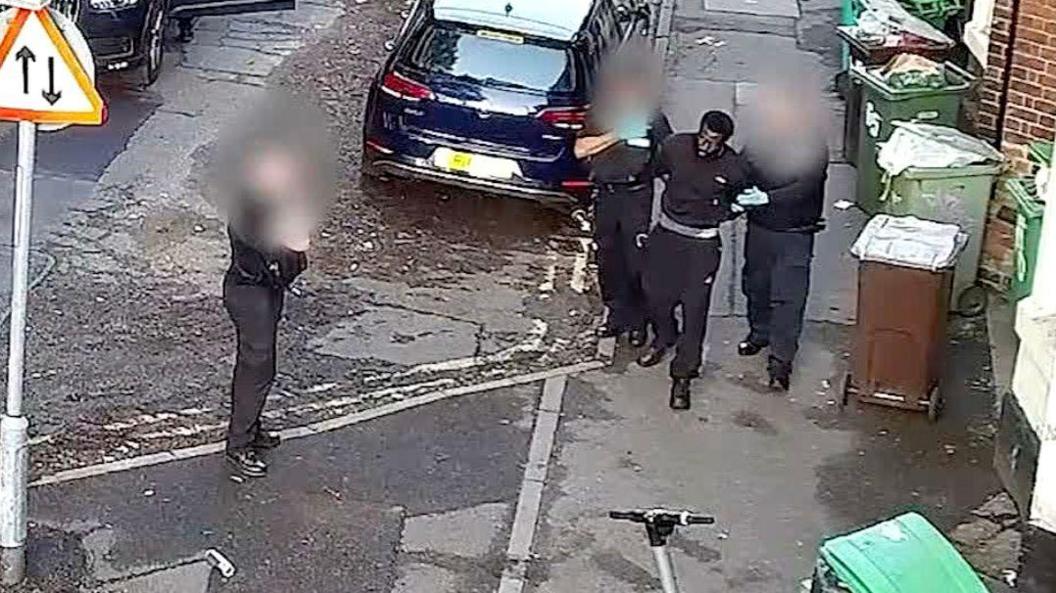 A CCTV image of Valdo Calocane being arrested on a street in Nottingham by three officers, whose faces are blurred in the image