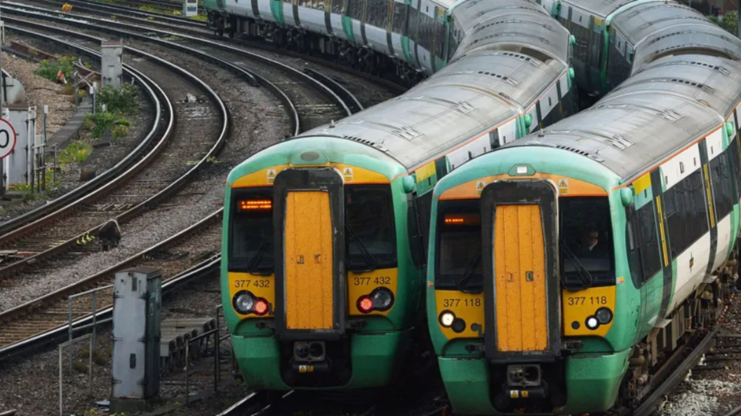 Two Southern Railway trains, in their green, white and yellow livery, sit side by side on a stretch of track.