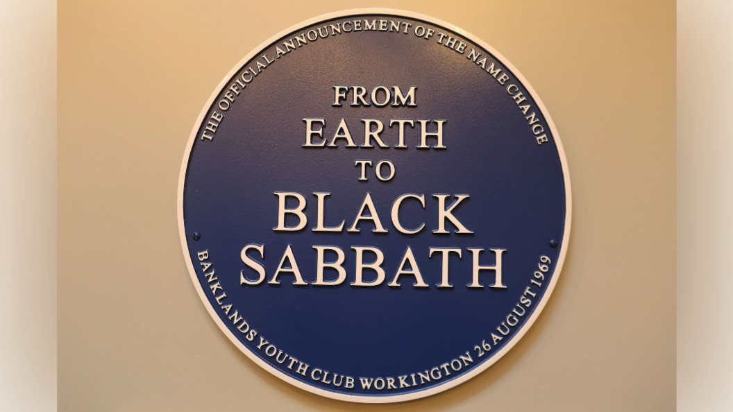 A blue circular plague on a wall. It reads 'From Earth to Black Sabbath'.