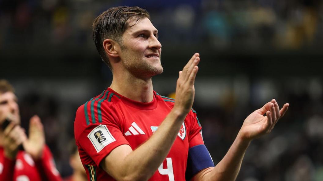 Wales captain Ben Davies applauds fans