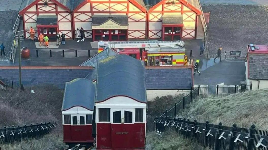 The red tramway with a fire engine and firefighters at the bottom of the hill