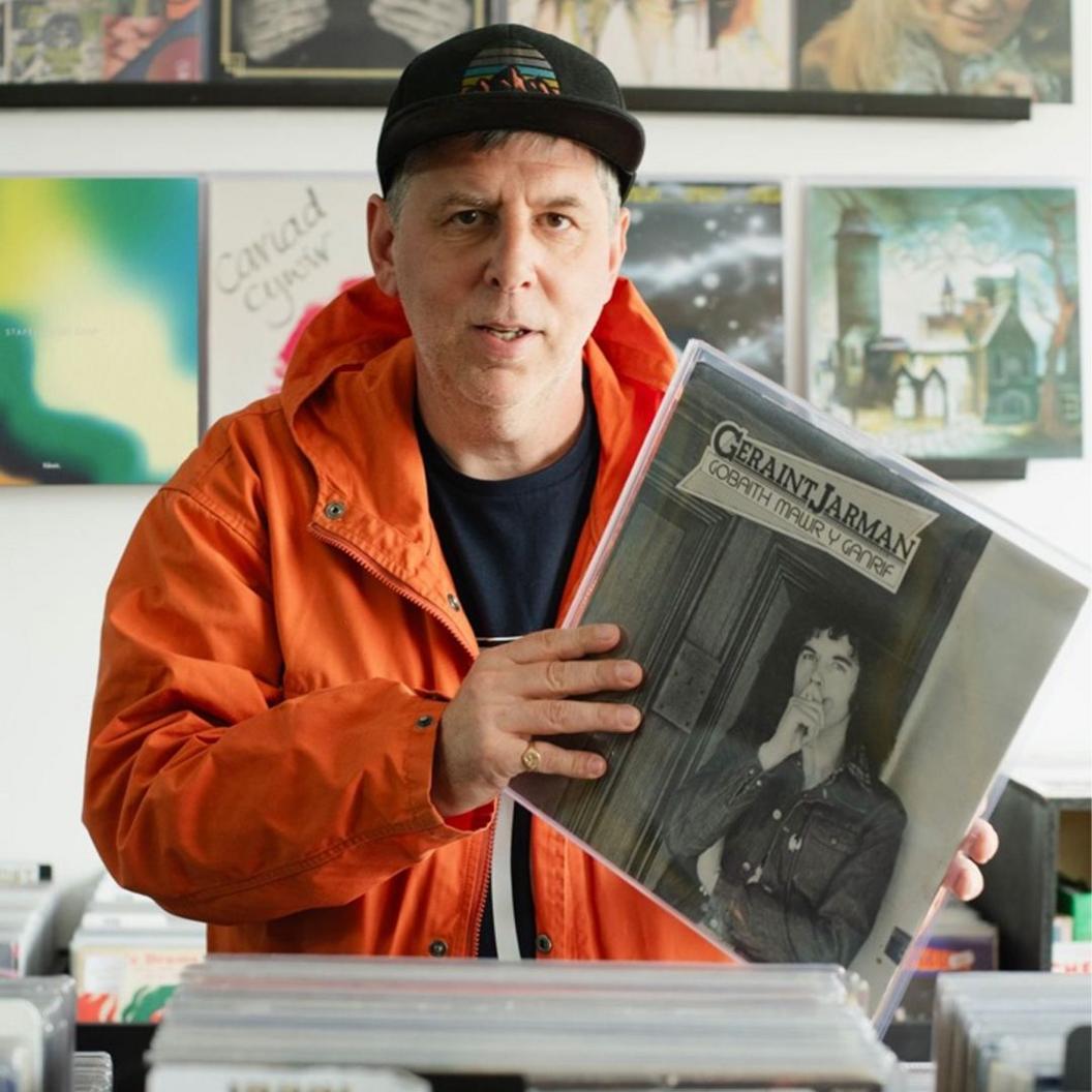 Kev Tame yn gafael ar copi o LP cyntaf Geraint Jarman 'Gobaith Mawr y Ganrif'