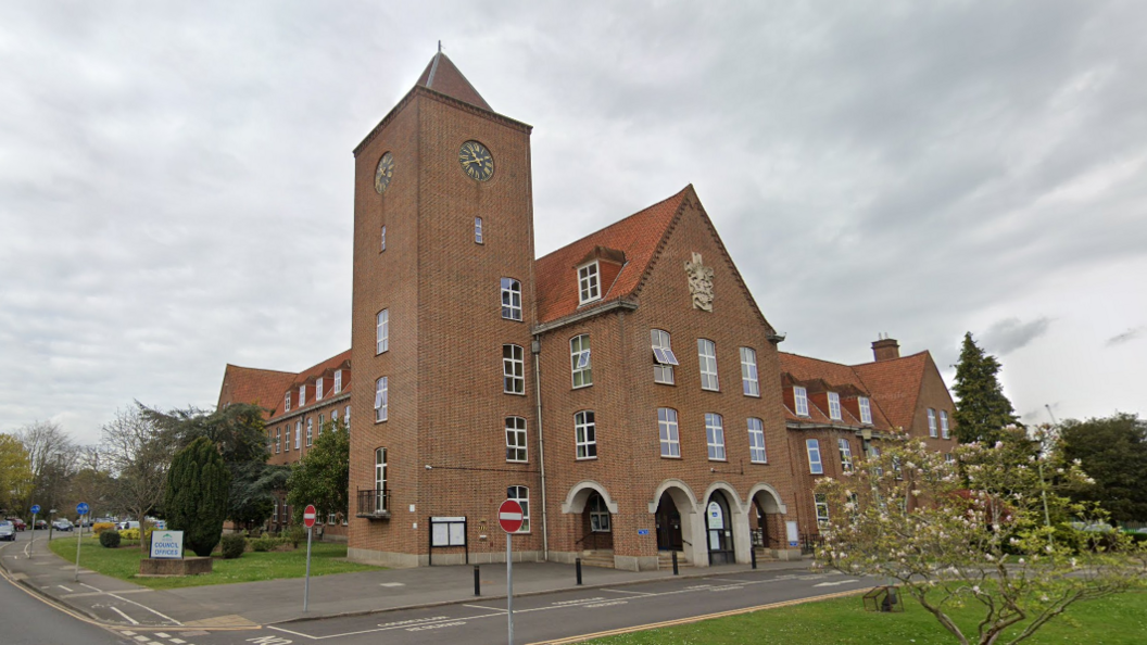 A red-bricked building with a clock tower.