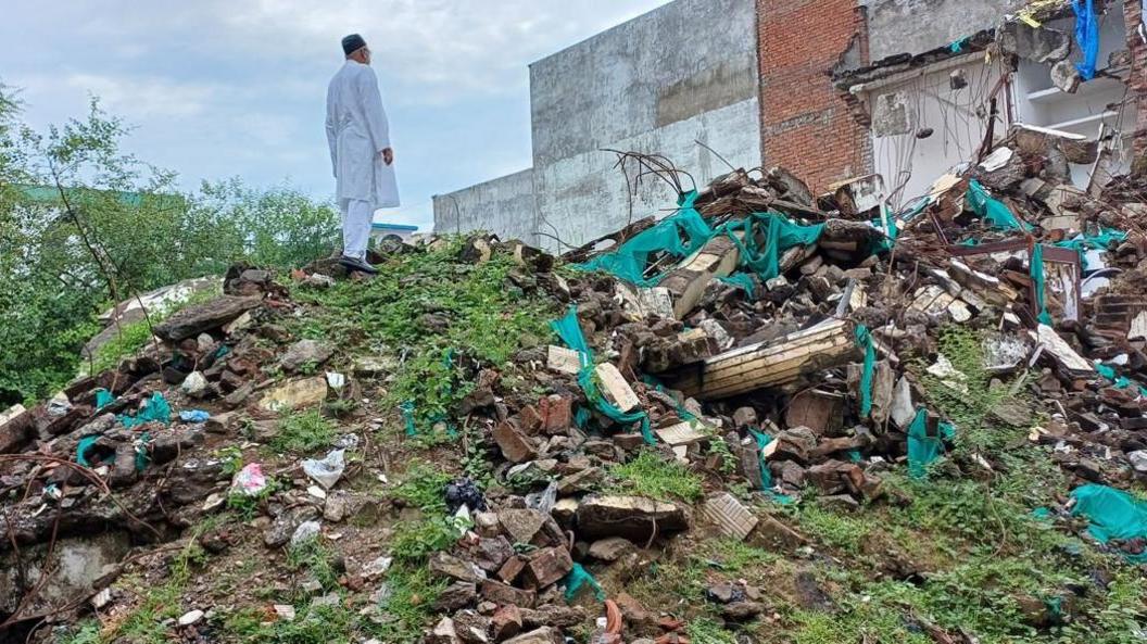 Javed Mohammad stands atop the debris, staring at where his house used to be before it was demolished in India's Uttar Pradesh state. 