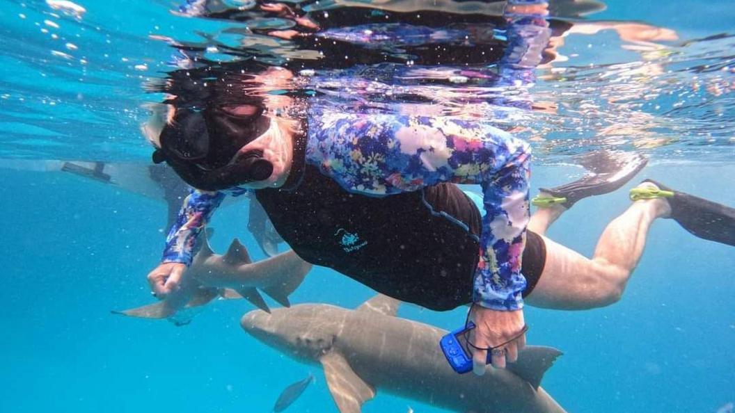 An underwater photo of Lynn Stephenson swimming in the sea wearing a snorkel. 