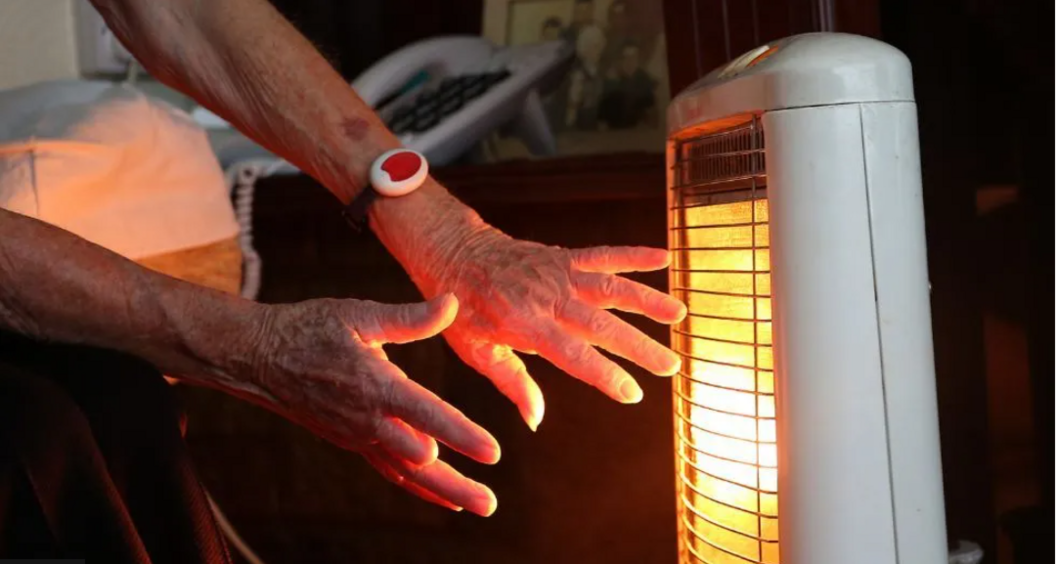 Elderly person using a heater