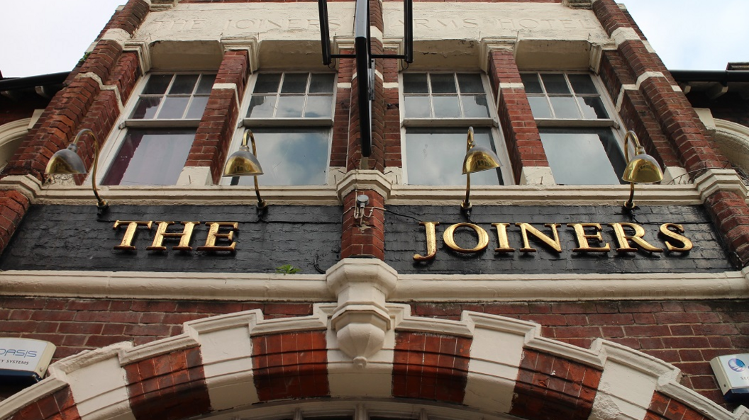 Looking up at The Joiners sign from outside.