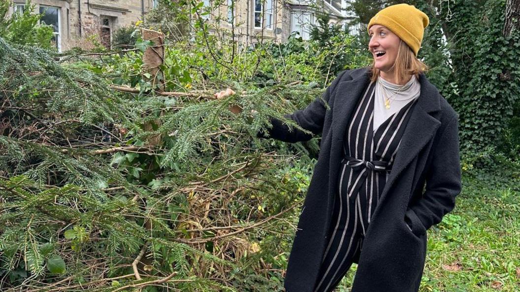 Sarah Yardley next to the chopped down tree