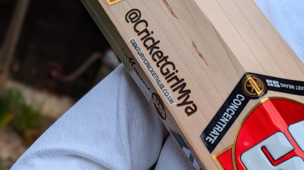 A close up of a cricket bat, with Cricket Girl Mya written on it.