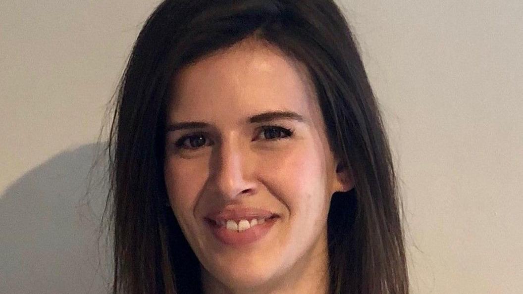 Close-up of Natasha Kurzeja smiling, with long dark brown hair