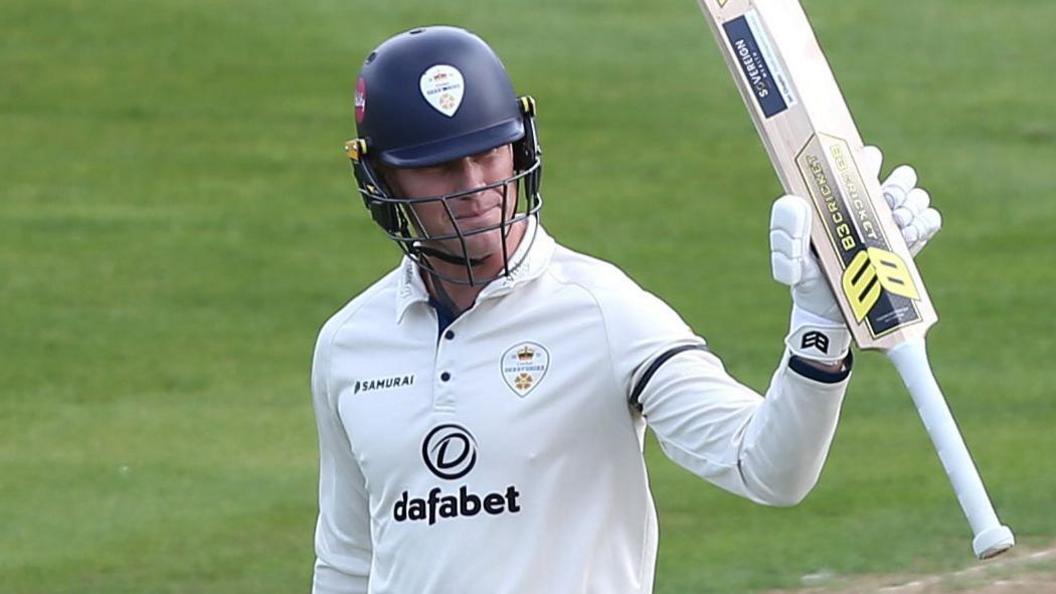 Luis Reece raises his bat to acknowledge applause from the crowd
