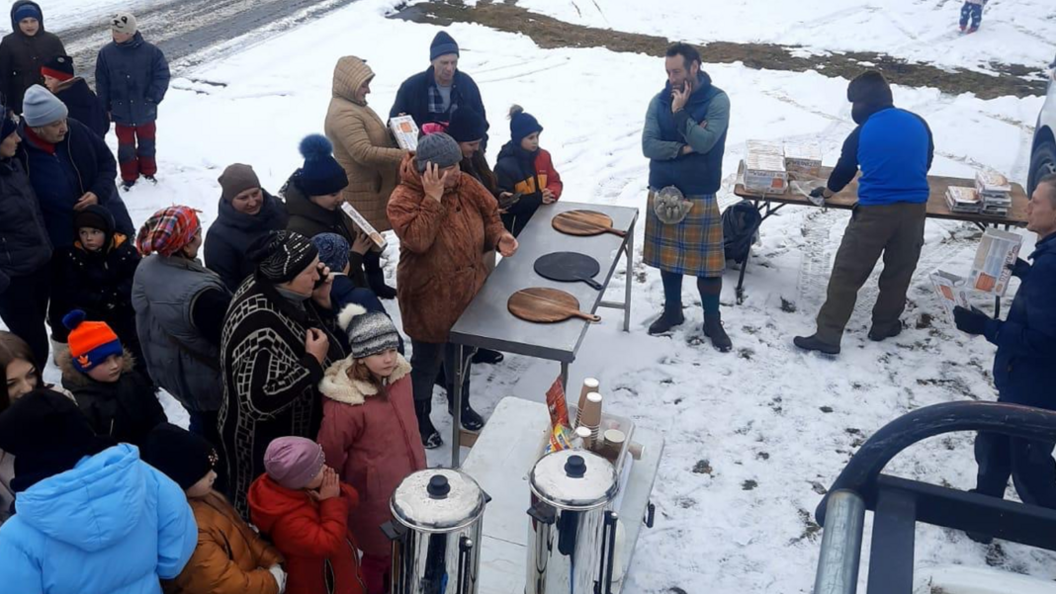 Tom and colleagues serving pizza to Ukrainians