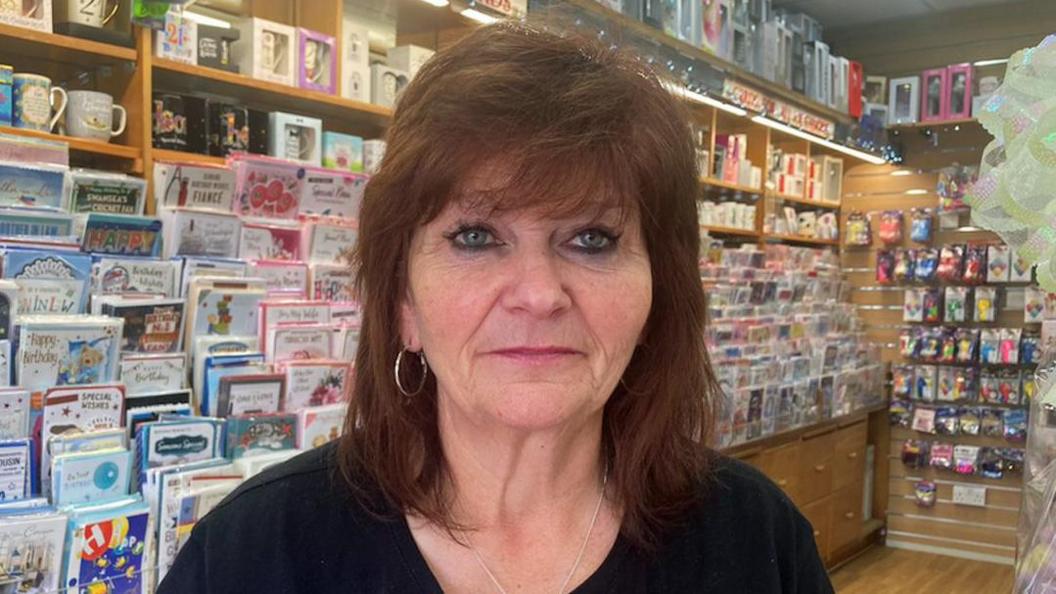 Julie Ruscitto in her shop, in front of rows of cards