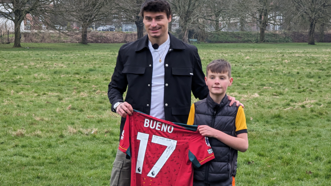 Oscar and Hugo Bueno holding a signed Bueno shirt