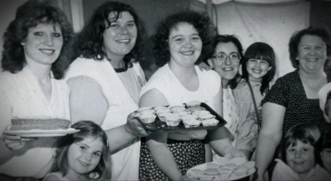 Women from the group pictured with a couple of their children 