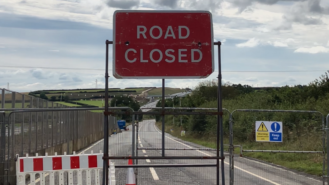 Road closed sign in front of empty road