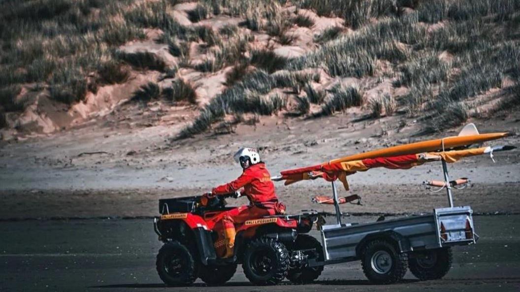 RNLI lifeguard on vehicle