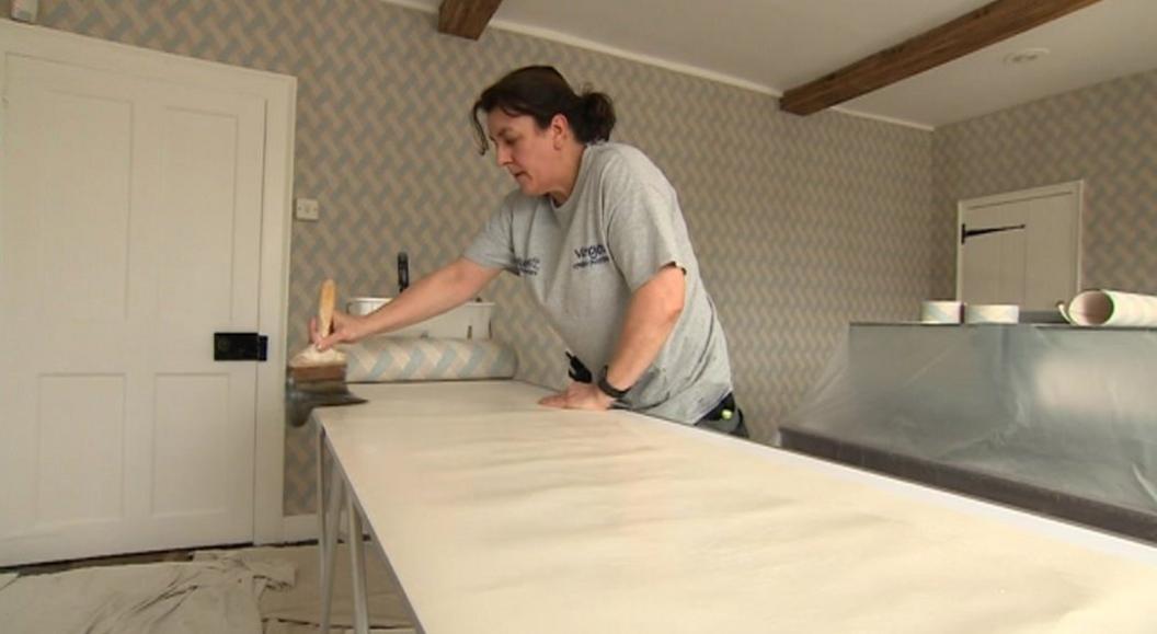 Decorator putting up wallpaper