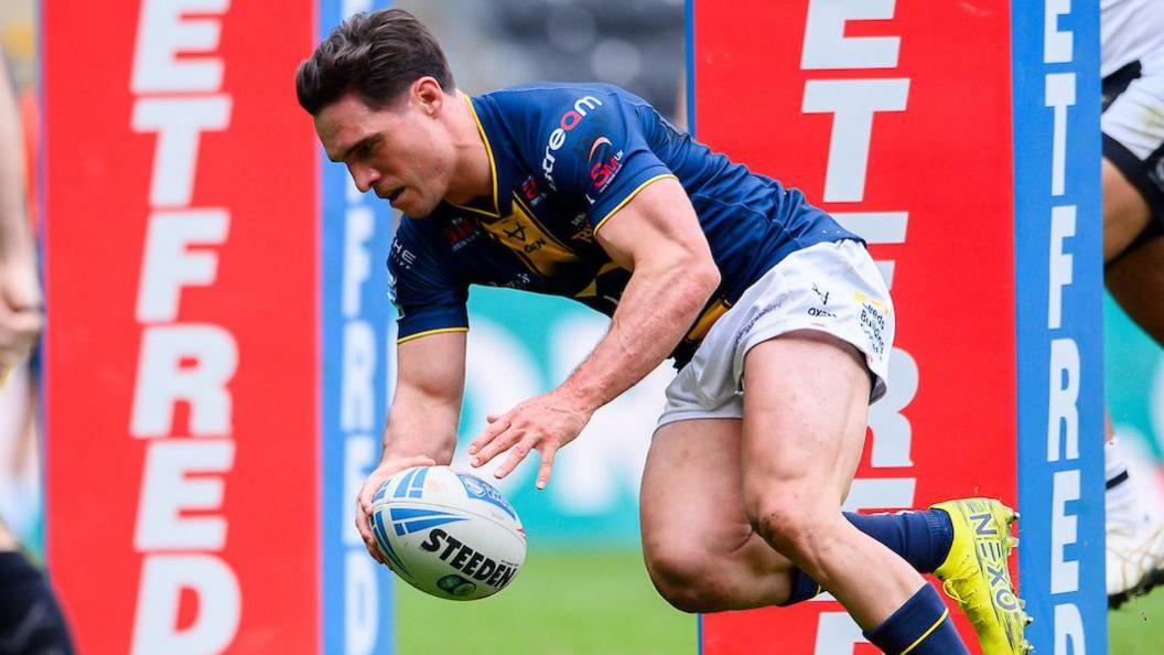 Leeds' Brodie Croft with his hand on the rugby ball before going down to score a try