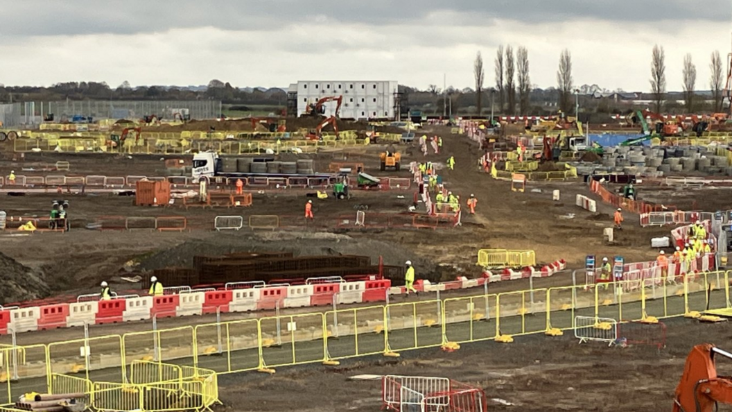 A large building site with workers scattered around.
