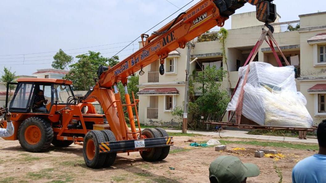 A photo of a crane lifting up the skeleton from the site in western Gujarat state, India.