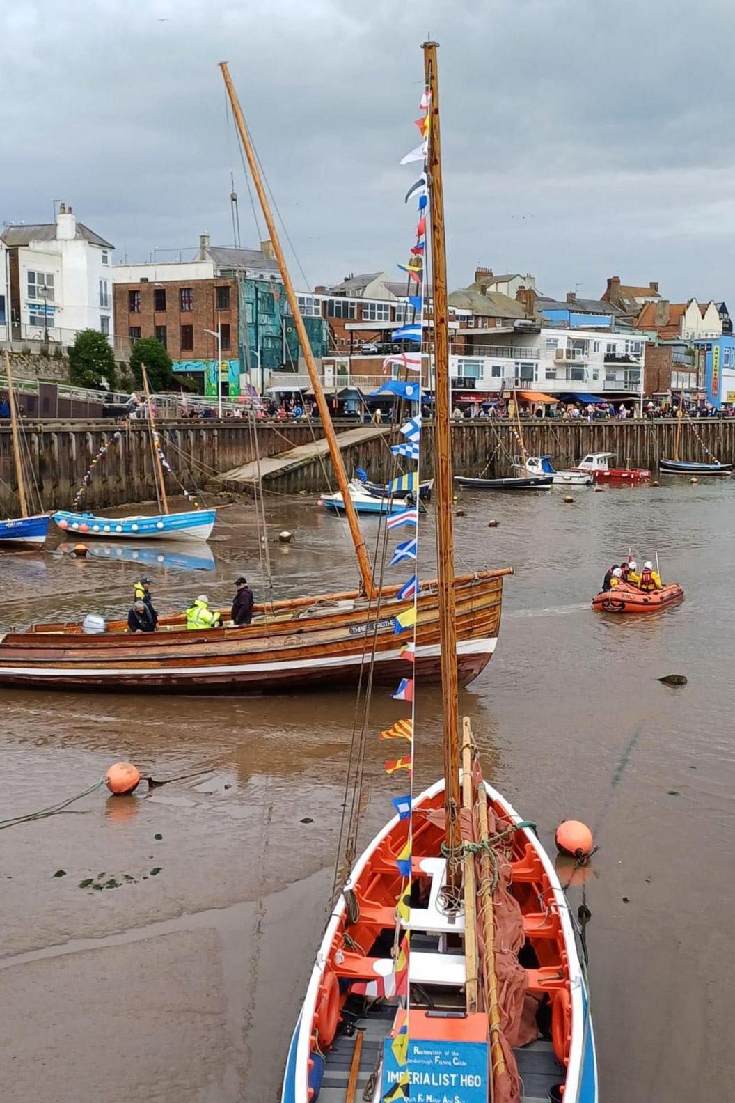 The Three Brothers wooden boat can be seen at low tide. All the boats around it are unable to move, apart from the lifeboat