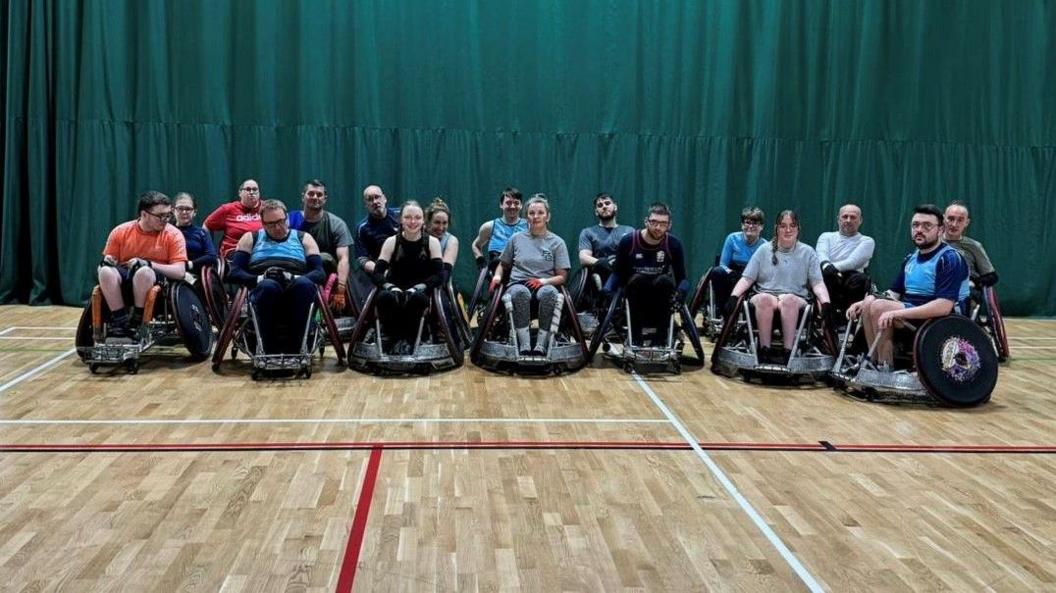 Stoke Mandeville Maulers players smiling for the camera during one of their recent training sessions. There is a green curtain behind them.