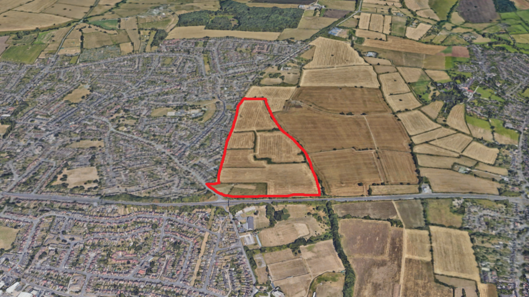 A satellite image of houses and a red area marked out where potential homes would be.