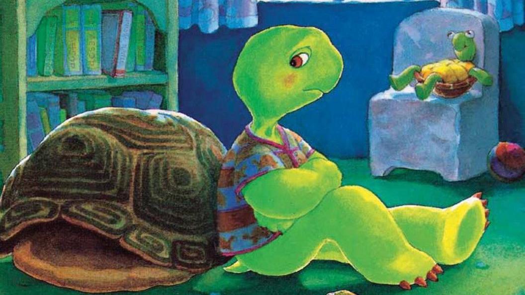 A cartoon image of Franklin the Turtle leaning against his shell, wearing a T-shirt in his bedroom and looking sad. 