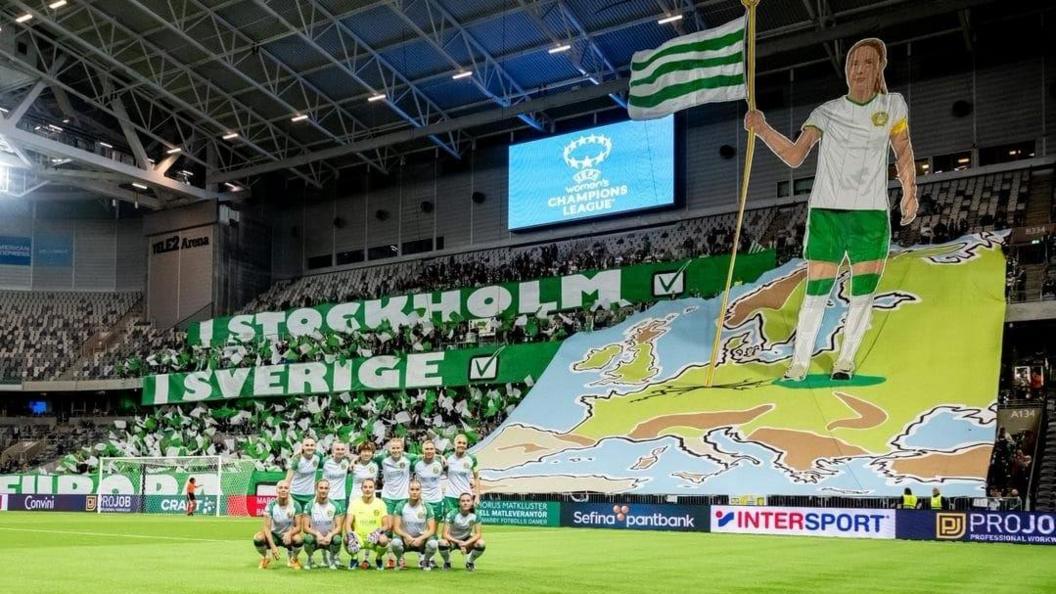 Hammarby players pose in front of a tifo before their Champions League qualifier against Benfica in September