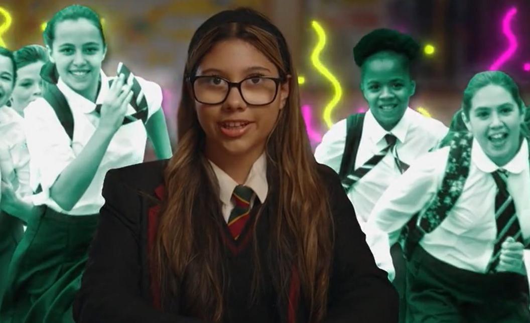 Girl in school uniform with headband, image of other children running in black and white are behind her.