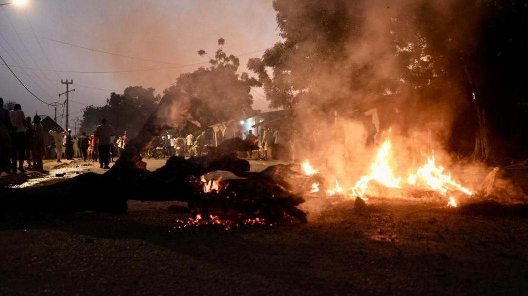 A large blaze near a tree that has fallen. 