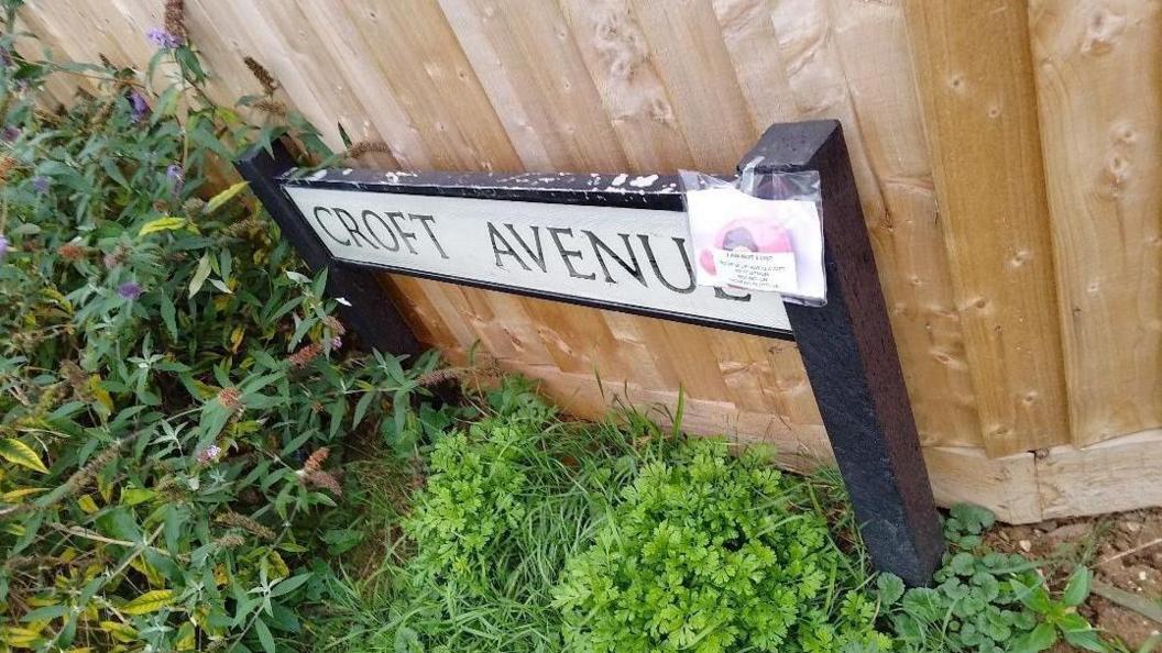 A knitted elephant attached to a street sign for Croft Avenue