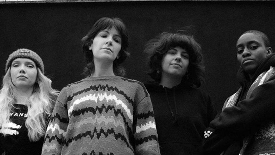 A black and white image of a group of women standing outdoors.